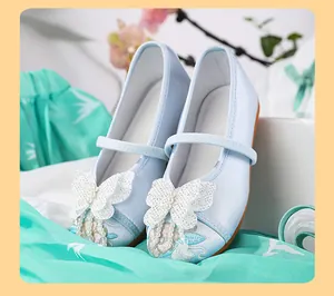 Close-up of light blue girls' Hanfu shoes with butterfly and pearl embroidery details