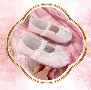 Close-up of pink girls' Hanfu shoes featuring a beaded butterfly and lace strap.