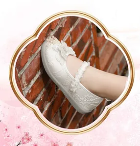 Close-up of white embroidered girl's hanfu shoe with pearl butterfly detail