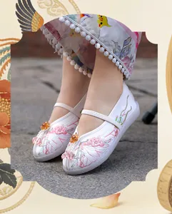 Close-up of girls' Chinese style embroidered shoes with pink floral patterns and beads