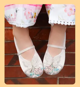 Close-up of girls' traditional embroidered Hanfu shoes with butterfly and pearl details