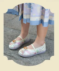 Detailed view of traditional Chinese embroidered Hanfu shoes for children on stone floor