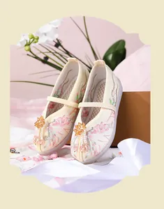 Detailed view of traditional Chinese Hanfu embroidered shoes for girls with beaded tassels.