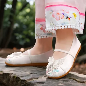 Traditional Chinese embroidered shoes for girls featuring elegant white butterfly floral patterns.