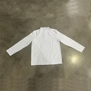 Detailed view of white linen long sleeve polo shirt in loose fit business casual style