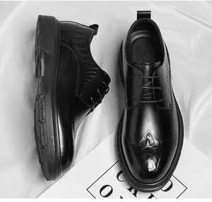 Close-up detail of black leather formal dress shoes with crocodile pattern embossing on toe