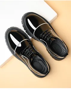 Detail of men's glossy black patent leather shoes with thick sole and white accents