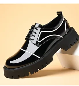 Close-up of black shiny patent leather men's shoes with thick soles and white piping