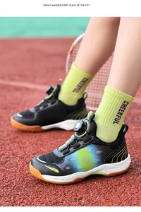 Detailed view of junior badminton shoes with rotary buckle on a red court