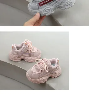Detailed view of lightweight breathable pink and grey children's sneakers on stone steps