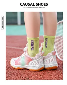 Detailed view of pink breathable kids' badminton shoes worn on an outdoor sports court