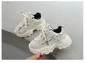 Detail of breathable cream kids' sports shoes showing mesh and velcro strap.