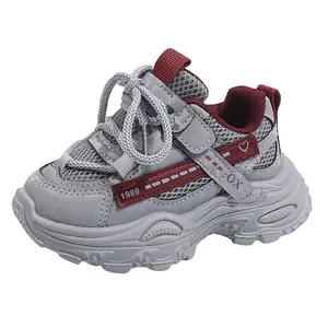 Detailed side view of breathable grey children's sneakers with stylish maroon accents