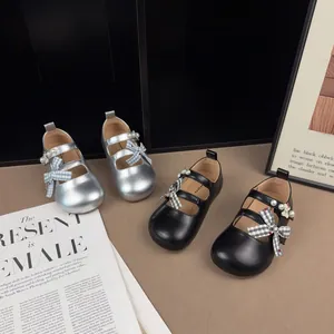 Vista dettagliata di scarpe da principessa per bambine nere e argento con fiocchi a quadri.