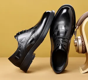 Detail view of men's black embossed leather brogue shoes with polished finish