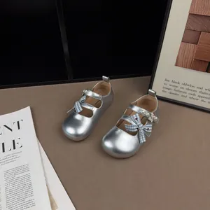 Dettaglio di scarpe da principessa argento per bambina con fiocco a quadri e perle