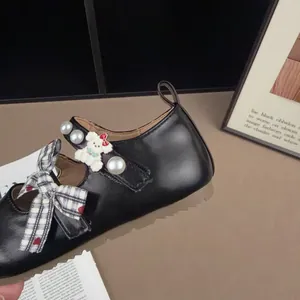 Vista dettagliata delle scarpe Mary Jane nere per bambine con fiocco e orsetto