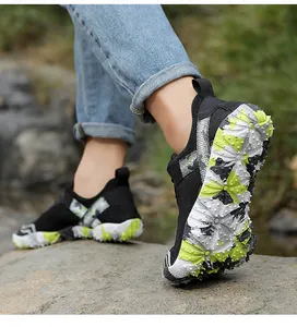 Detailed view of the non-slip patterned sole on black outdoor hiking shoes on a rock