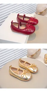 Nahaufnahme von roten und goldenen Mädchen-Mary-Janes mit Schleifen und weichen Sohlen.