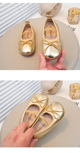 Detailaufnahme goldener Baby Prinzessin Schuhe mit Schleife und glänzender Metalloptik