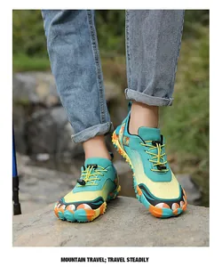 Outdoor hiking shoes with colorful grip soles and elastic laces on rocky terrain