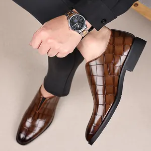 Vista detallada de elegantes zapatos de cuero marrón para hombre con textura piedra