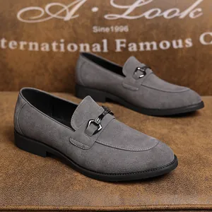 Detailweergave van grijze suède loafers voor heren met een decoratieve zwarte metalen gesp