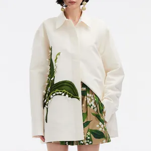 Elegant cream oversized shirt featuring delicate lily of the valley floral embroidery
