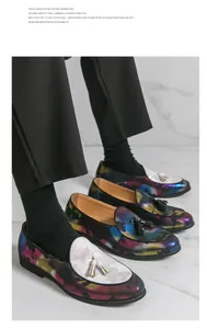 Detailaufnahme der bunten Camouflage-Loafer für Herren mit Quasten auf Marmor