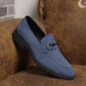 Close-up van blauwe suède loafers voor heren met metalen gesp detail.