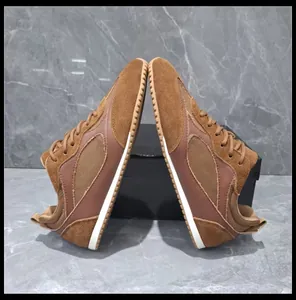 Symmetrical side view of retro brown suede German Army Trainers on marble background