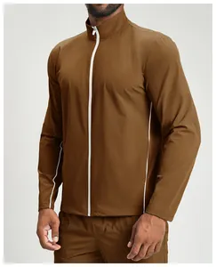 Gros plan d'une veste de sport marron pour homme avec fermeture éclair et liserés blancs