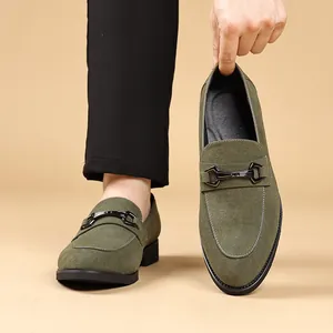 Detailweergave van olijfgroene suède loafers met een klassieke metalen gesp.