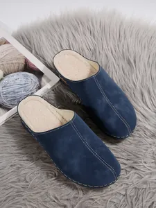 Detail view of navy blue wedge cotton slippers with warm fleece lining and sturdy platform sole.