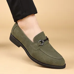 Detailopname van luxe groene suède loafers voor heren met een metalen gespdetail.