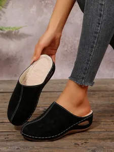 Warm black fleece-lined wedge slippers featuring elegant white contrast stitching