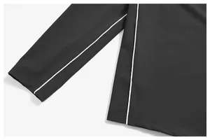 Détail en gros plan de la tuyauterie blanche sur une veste de sport noire.