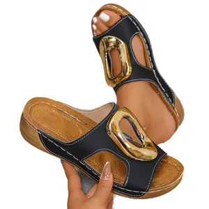 Elegant black women's open toe wedge sandals featuring a large decorative gold buckle