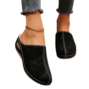 Women's black faux suede wedge slippers with white stitching and platform sole