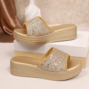 Close-up detail of golden glitter straps and textured platform wedge slippers