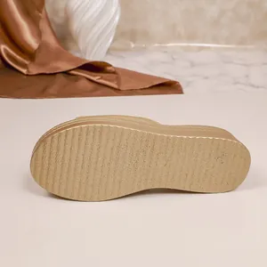 Detail showing the textured non-slip outsole and platform of a golden fashion slipper
