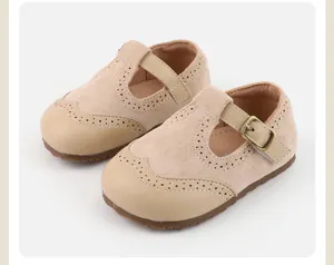 Detailed view of beige suede baby girls Mary Jane shoes featuring classic brogue patterns