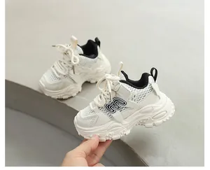Détail montrant la maille respirante et le logo sur les baskets blanches pour enfants.