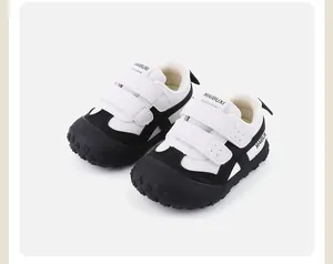Vista detallada de zapatillas infantiles en blanco y negro con correas de velcro dobles