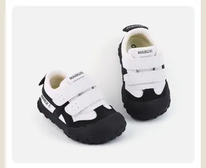 Primer plano de zapatillas casuales para niños en blanco y negro con velcro y suela blanda.