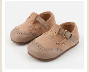 Close-up detail of beige baby girl Mary Jane shoes with soft non-slip soles and brogue