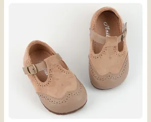 Overhead view of tan suede baby Mary Jane shoes featuring elegant brogue cutout details