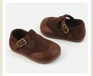 Detail showing brown suede baby Mary Jane shoes with brogue patterns and non-slip soft sole.
