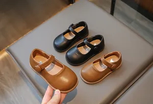Gros plan de chaussures Mary Jane pour filles en noir et marron avec fermetures velcro