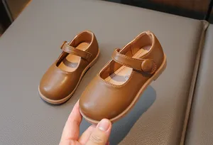 Chaussures Mary Jane marron pour fille avec semelle souple et bande velcro.